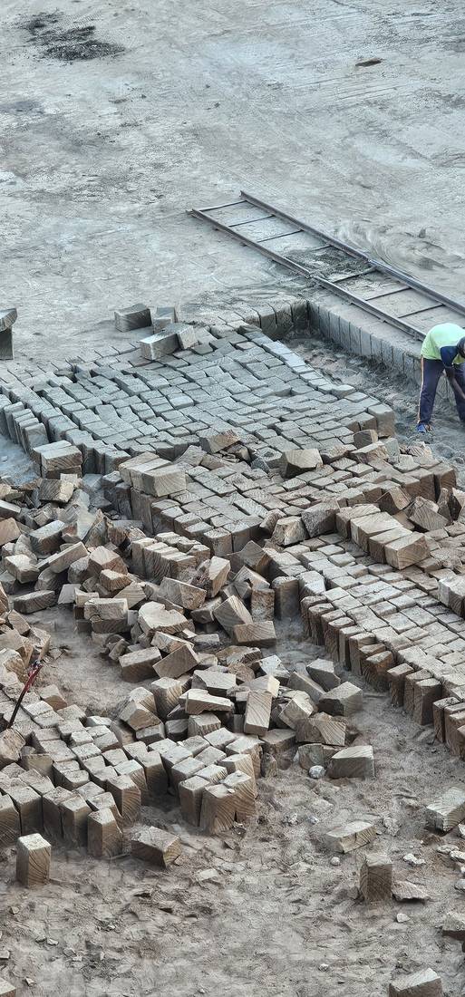 Rows of cut stone blocks and a worker at the quarry
