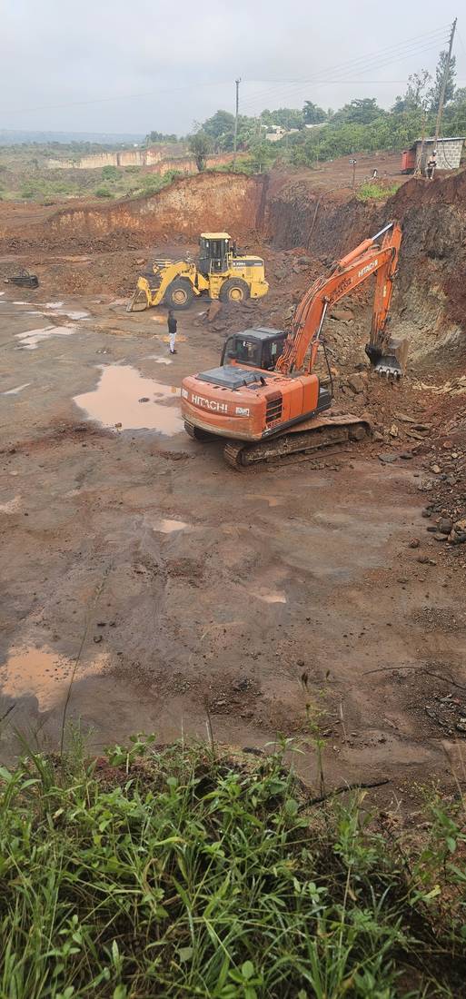 Excavator and wheel loader working the quarry face