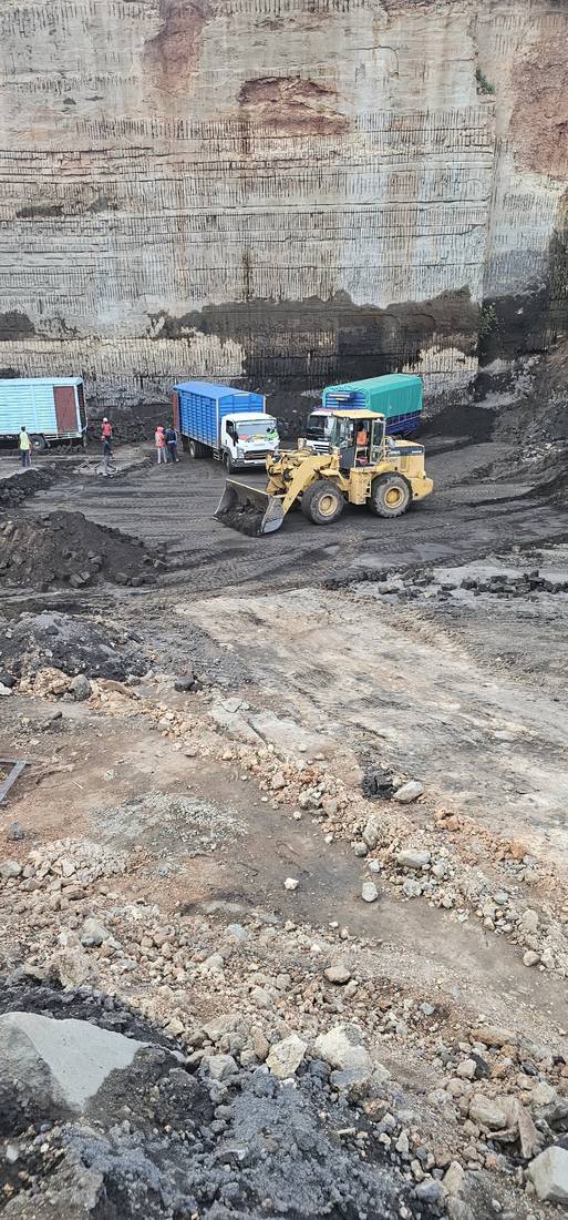 Wheel loader and delivery trucks at the quarry base