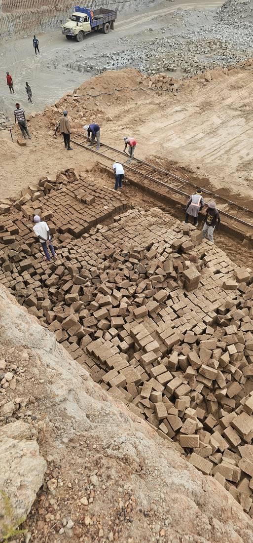 Quarry floor with cut stone stacked in rows, seen from above