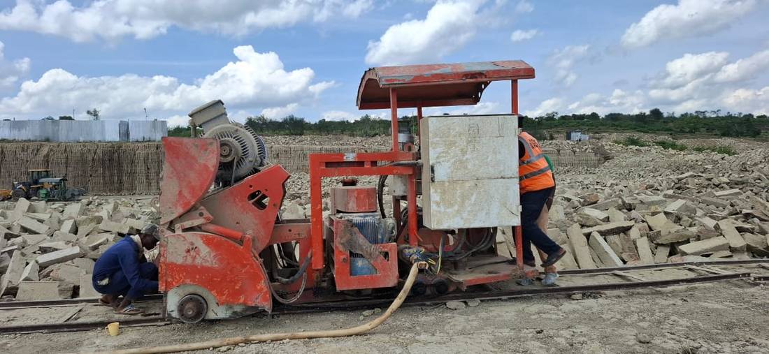 Stone-cutting saw with two workers on site