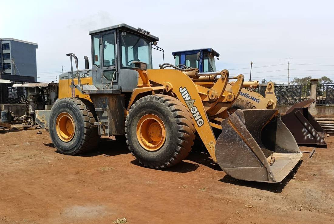 Yellow wheel loader with bucket at the yard